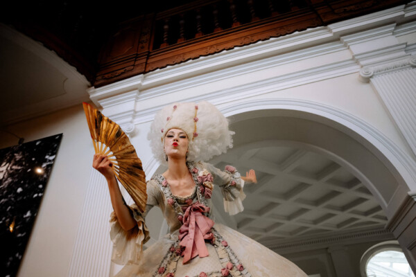 Eine Frau geschminkt auf Stelzen