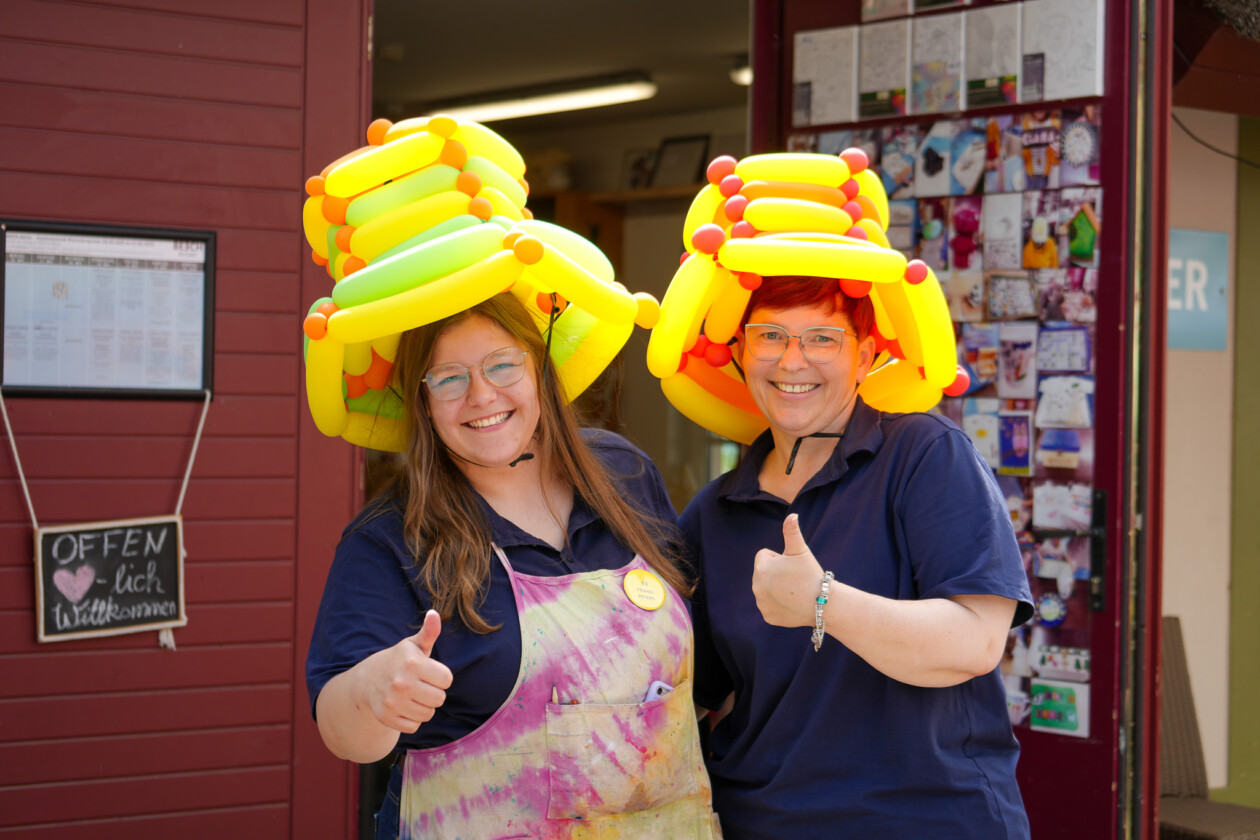 Zwei Frauen mit lustigen Hüten lachen