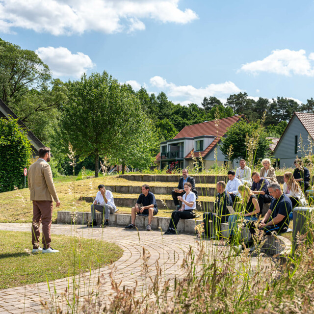 Viele Leute sitzen zusammen, ein Moderator